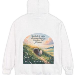 White Comfort Colors hoodie sweatshirt with a field and an open tomb with the rock rolled away. Printed on it is 1 Corinthians 15:57 But thanks be to God, who gives us the victory through our Lord Jesus Christ.