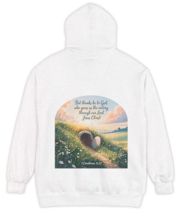 White Comfort Colors hoodie sweatshirt with a field and an open tomb with the rock rolled away. Printed on it is 1 Corinthians 15:57 But thanks be to God, who gives us the victory through our Lord Jesus Christ.