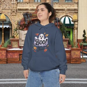 Model on a Halloween set wearing a Gray Boo! -lieve in Jesus Halloween Hoodie, design showing a cute ghost with fall leaves.