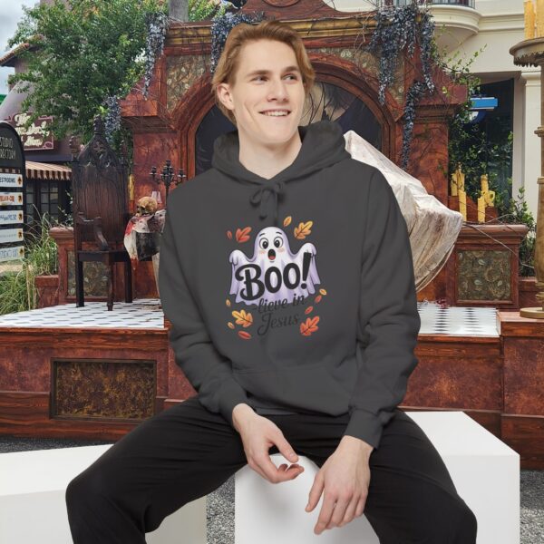 Model on a Halloween set wearing a Gray Boo! -lieve in Jesus Halloween Hoodie, design showing a cute ghost with fall leaves.