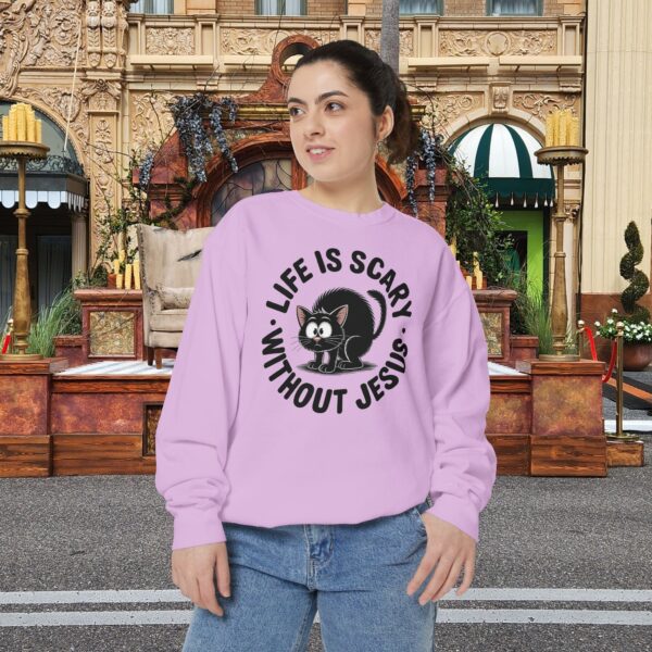 Model on a Halloween set wearing a Pink Life is Scary Without Jesus Halloween Sweatshirt, design showing a cute frightened black cat.