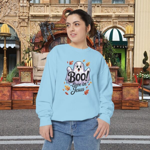Model on a Halloween set wearing a Blue Boo! -lieve in Jesus Halloween Sweatshirt, design showing a cute ghost with fall leaves.