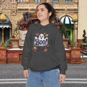 Model on a Halloween set wearing a Gray Boo! -lieve in Jesus Halloween Hoodie, design showing a cute ghost with fall leaves.