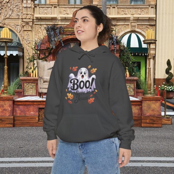 Model on a Halloween set wearing a Gray Boo! -lieve in Jesus Halloween Hoodie, design showing a cute ghost with fall leaves.