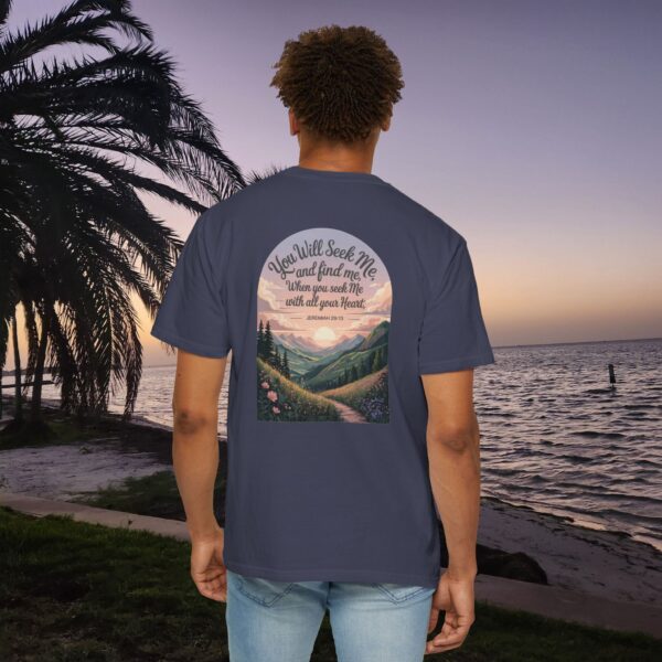 Navy Christian t-shirt with Jeremiah 29:13 scripture, mountain valley, and sunset graphic, worn by a person in a serene beach setting.