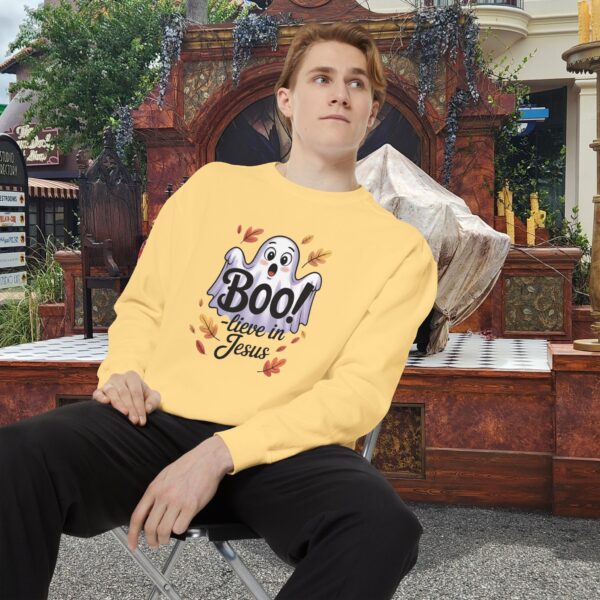 Model on a Halloween set wearing a Yellow Boo! -lieve in Jesus Halloween Sweatshirt, design showing a cute ghost with fall leaves.
