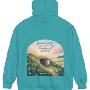 Tropical blue green Comfort Colors hoodie sweatshirt with a field and an open tomb with the rock rolled away. Printed on it is 1 Corinthians 15:57 But thanks be to God, who gives us the victory through our Lord Jesus Christ.