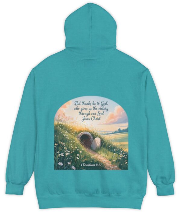 Tropical blue green Comfort Colors hoodie sweatshirt with a field and an open tomb with the rock rolled away. Printed on it is 1 Corinthians 15:57 But thanks be to God, who gives us the victory through our Lord Jesus Christ.
