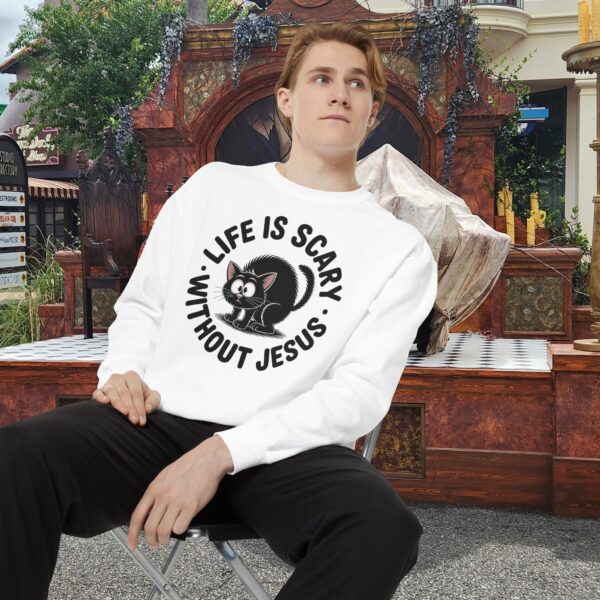 Model on a Halloween set wearing a white Life is Scary Without Jesus Halloween Sweatshirt, design showing a cute frightened black cat.