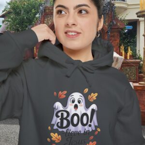 Model on a Halloween set wearing a Gray Boo! -lieve in Jesus Halloween Hoodie, design showing a cute ghost with fall leaves.