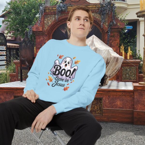 Model on a Halloween set wearing a Blue Boo! -lieve in Jesus Halloween Sweatshirt, design showing a cute ghost with fall leaves.