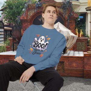 Model on a Halloween set wearing a Blue Boo! -lieve in Jesus Halloween Sweatshirt, design showing a cute ghost with fall leaves.