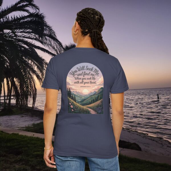 Navy Christian t-shirt with Jeremiah 29:13 scripture, mountain valley, and sunset graphic, worn by a person in a serene beach setting.