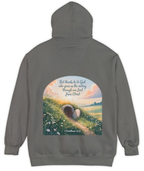 Grey Comfort Colors hoodie sweatshirt with a field and an open tomb with the rock rolled away. Printed on it is 1 Corinthians 15:57 But thanks be to God, who gives us the victory through our Lord Jesus Christ.