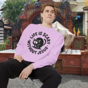 Model on a Halloween set wearing a Pink Life is Scary Without Jesus Halloween Sweatshirt, design showing a cute frightened black cat.