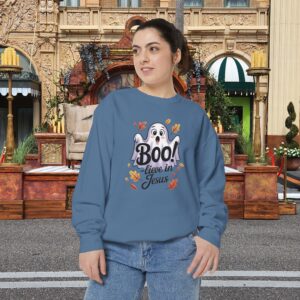 Model on a Halloween set wearing a Blue Boo! -lieve in Jesus Halloween Sweatshirt, design showing a cute ghost with fall leaves.
