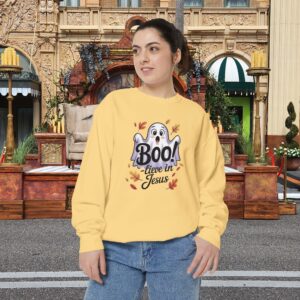 Model on a Halloween set wearing a Yellow Boo! -lieve in Jesus Halloween Sweatshirt, design showing a cute ghost with fall leaves.