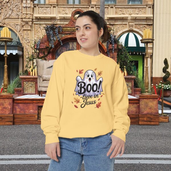 Model on a Halloween set wearing a Yellow Boo! -lieve in Jesus Halloween Sweatshirt, design showing a cute ghost with fall leaves.