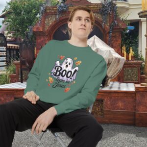 Model on a Halloween set wearing a Green Boo! -lieve in Jesus Halloween Sweatshirt, design showing a cute ghost with fall leaves.