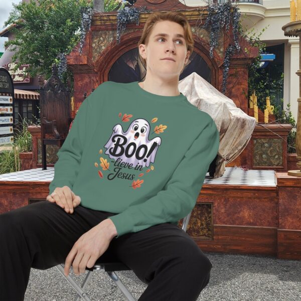 Model on a Halloween set wearing a Green Boo! -lieve in Jesus Halloween Sweatshirt, design showing a cute ghost with fall leaves.