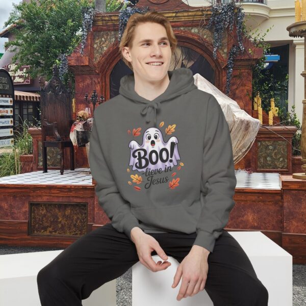 Model on a Halloween set wearing a Gray Boo! -lieve in Jesus Halloween Hoodie, design showing a cute ghost with fall leaves.