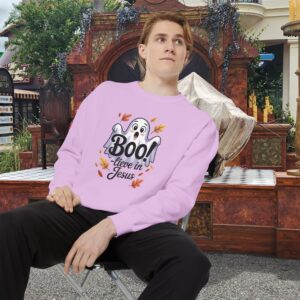 Model on a Halloween set wearing a Pink Boo! -lieve in Jesus Halloween Sweatshirt, design showing a cute ghost with fall leaves.