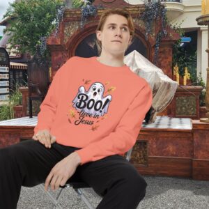 Model on a Halloween set wearing an Orange Boo! -lieve in Jesus Halloween Sweatshirt, design showing a cute ghost with fall leaves.