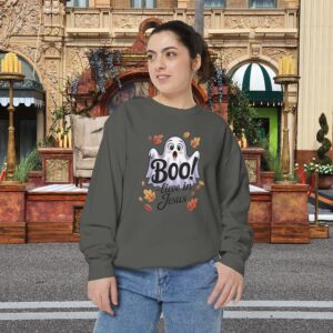 Model on a Halloween set wearing a Gray Boo! -lieve in Jesus Halloween Sweatshirt, design showing a cute ghost with fall leaves.
