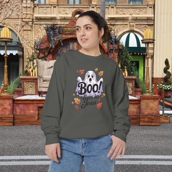 Model on a Halloween set wearing a Gray Boo! -lieve in Jesus Halloween Sweatshirt, design showing a cute ghost with fall leaves.