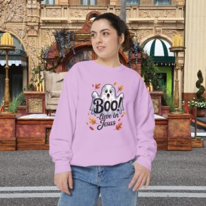Model on a Halloween set wearing a Pink Boo! -lieve in Jesus Halloween Sweatshirt, design showing a cute ghost with fall leaves.