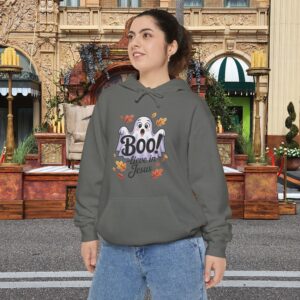 Model on a Halloween set wearing a Gray Boo! -lieve in Jesus Halloween Hoodie, design showing a cute ghost with fall leaves.