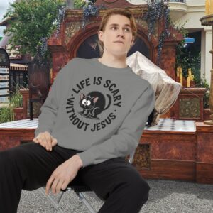 Model on a Halloween set wearing a gray Life is Scary Without Jesus Halloween Sweatshirt, design showing a cute frightened black cat.