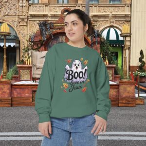 Model on a Halloween set wearing a Green Boo! -lieve in Jesus Halloween Sweatshirt, design showing a cute ghost with fall leaves.