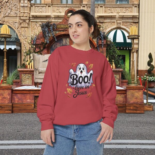 Model on a Halloween set wearing a Red Boo! -lieve in Jesus Halloween Sweatshirt, design showing a cute ghost with fall leaves.