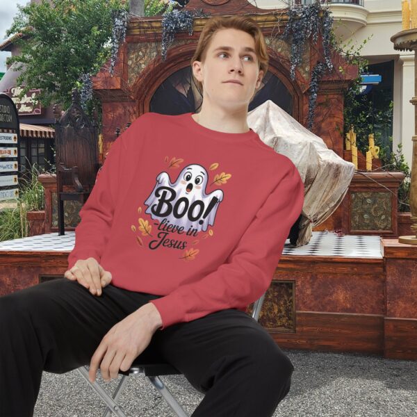 Model on a Halloween set wearing a Red Boo! -lieve in Jesus Halloween Sweatshirt, design showing a cute ghost with fall leaves.